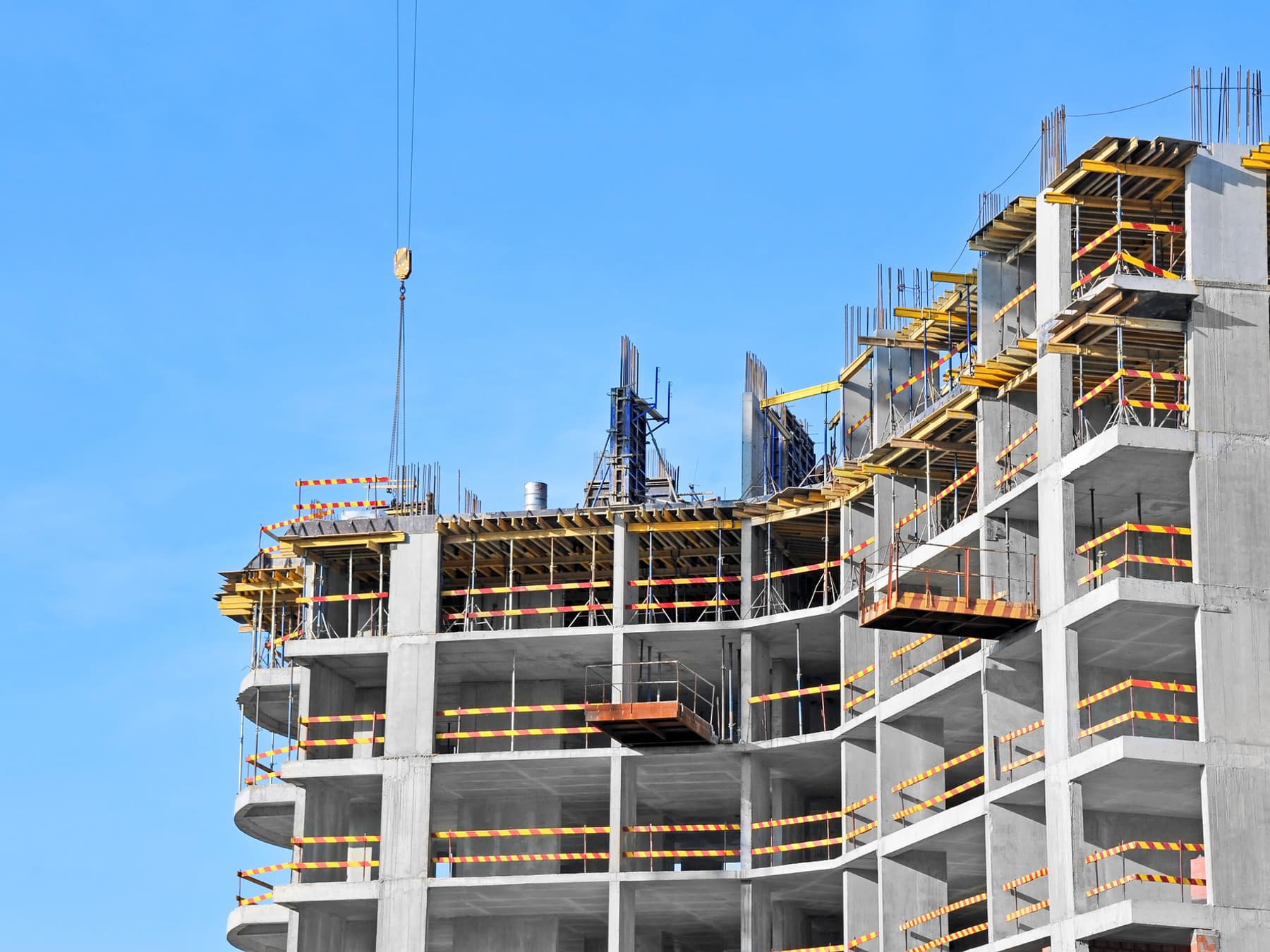 Reinforced concrete frame under construction against a clear sky